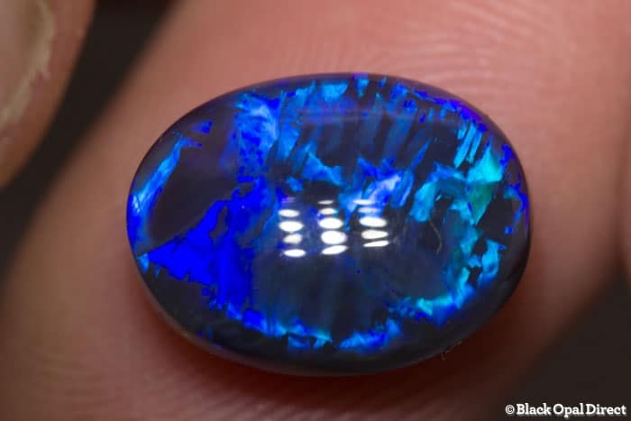 5.85 ct blue opal with chinese writing 14x10.5x6mm